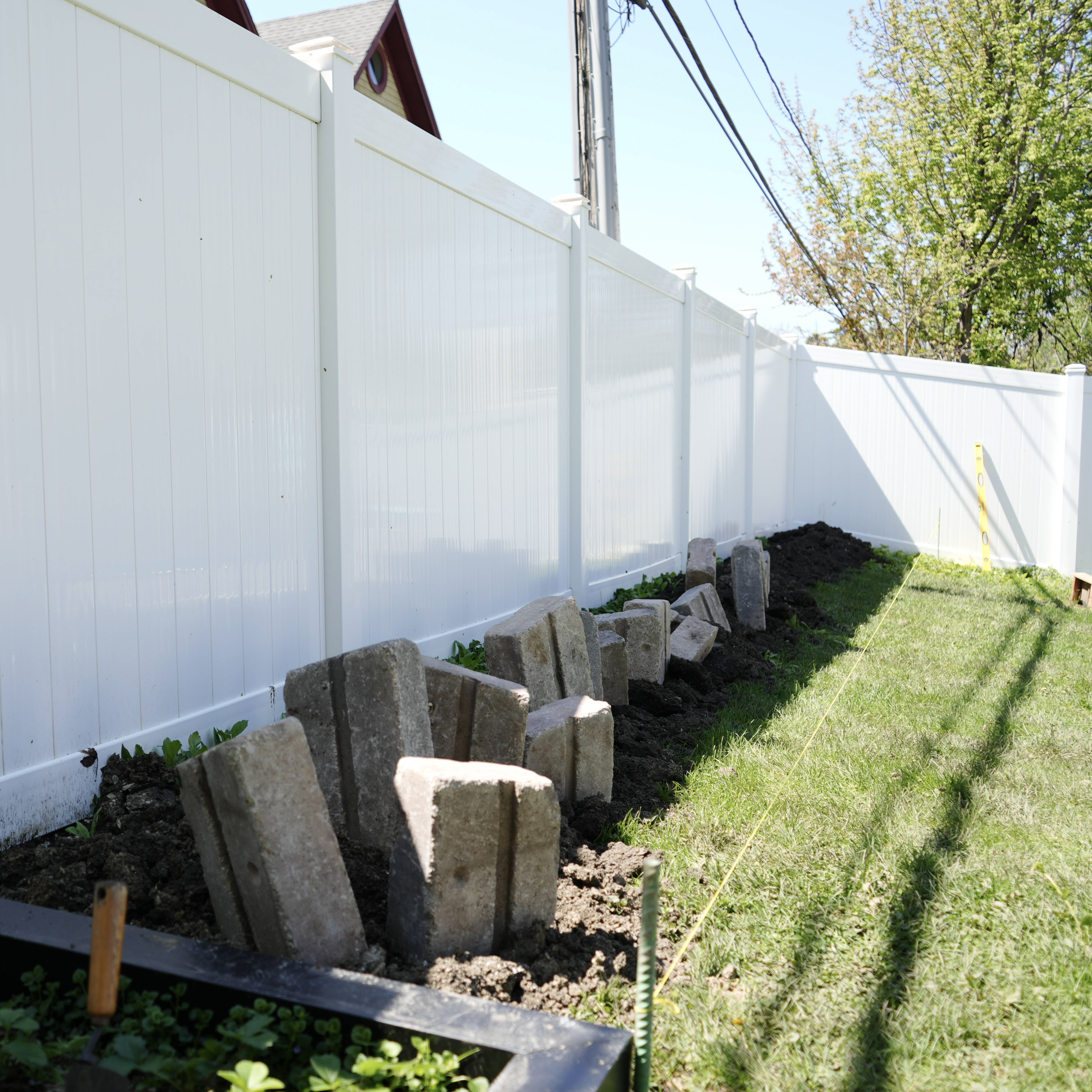 Paver bricks being laid by hand along a clean stone-edge run.